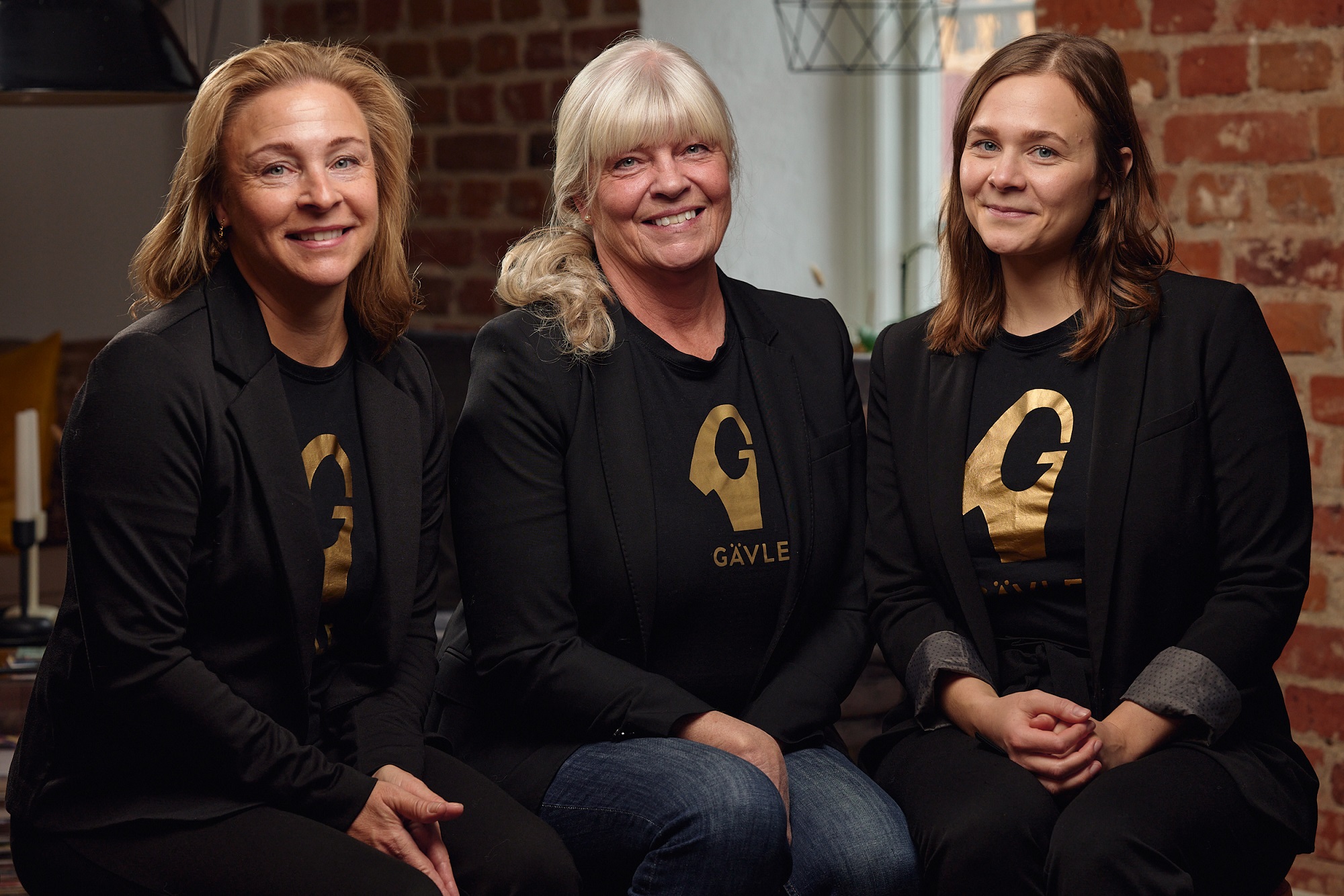 Tre kvinnor i svarta tröjor med G i guld. Foto Michael Tebinka, Baringo.