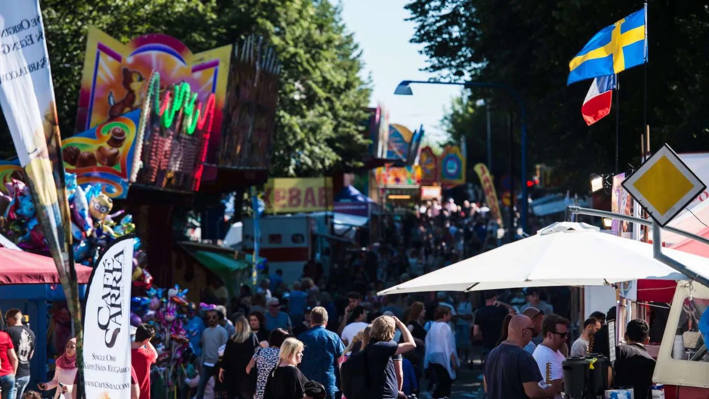 Stadsfest med mycket folk, vimplar och flaggor