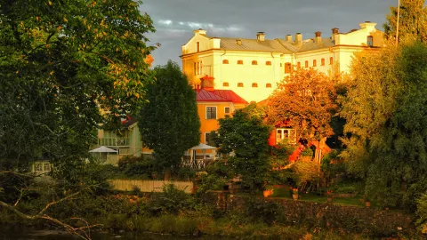 Höstsol lyser på stor herrgårdsliknande byggnad