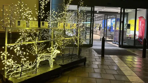 Entre till ett köpcentrum med belysta prydnadsrenar utanför en kväll inför jul