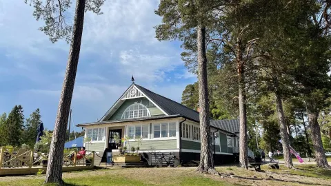 Grön träbyggnad i en skogsglänta