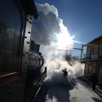 Stins i motljus som tar emot ett ankommande ånglok