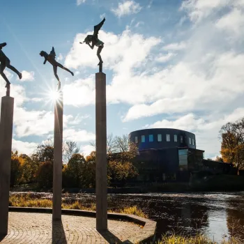 Gävle konserthus i bakgrunden, statyer i förgrunden och vatten däremellan