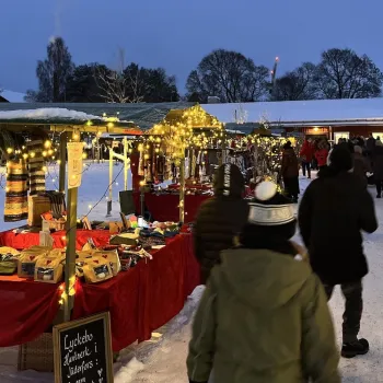 Julmarknad med bord och besökare en kväll