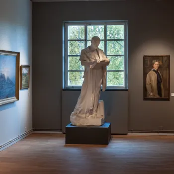 Skyview över stor Länsmuseet Gävleborgs stora röda tegelbyggnad som ligger vid träd och vatten