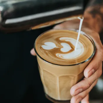 Mjölk tappas upp i ett glas med kaffe