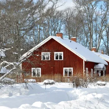 Röd stuga i ett vinterlandskap